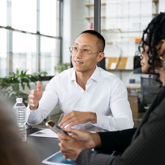 Man presenting to others at a table