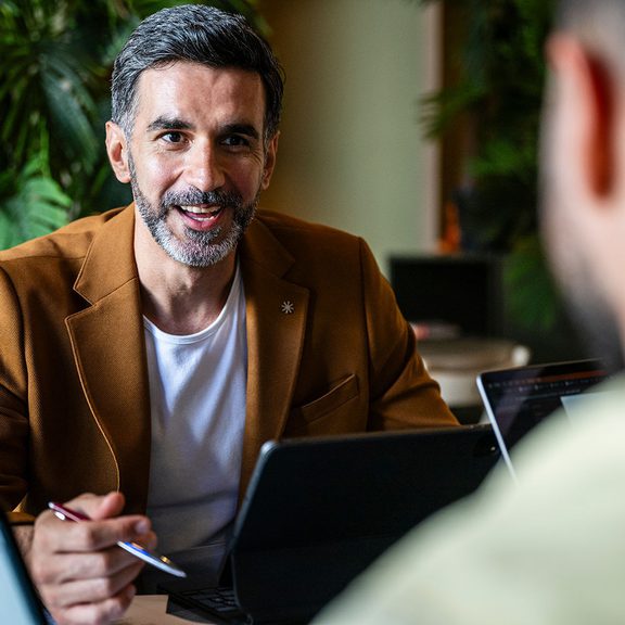 Man talking in front of a computer