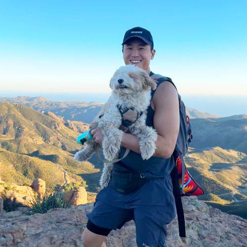 Photo of person with dog on mountain top