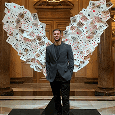 Photo of person in front of wings made of playing cards