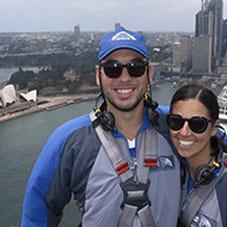 Photo of two people in front of a body of water