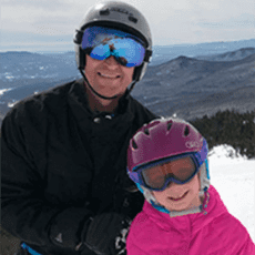 Photo of a person and child in goggles and snow gear