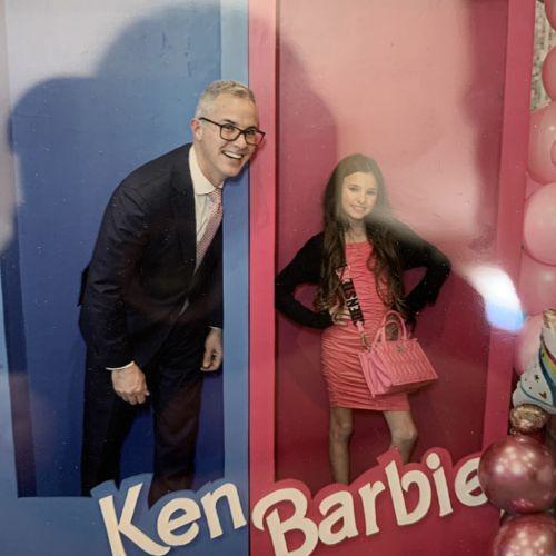 Photo of a person and a child in large doll boxes