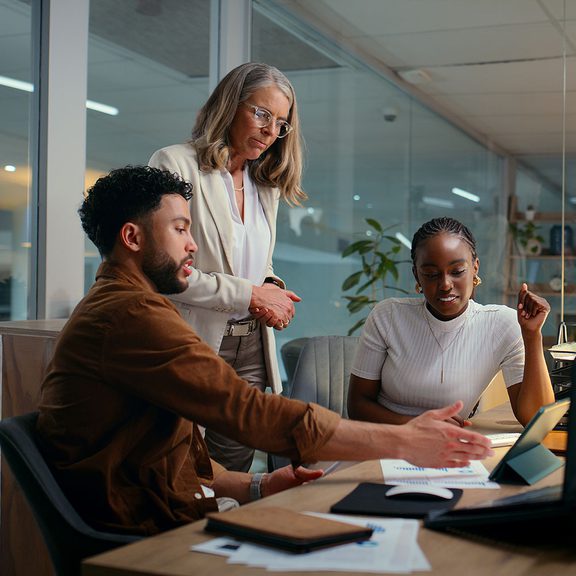 Three people viewing information on a tablet