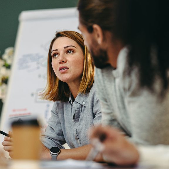 Woman talking to team around a table